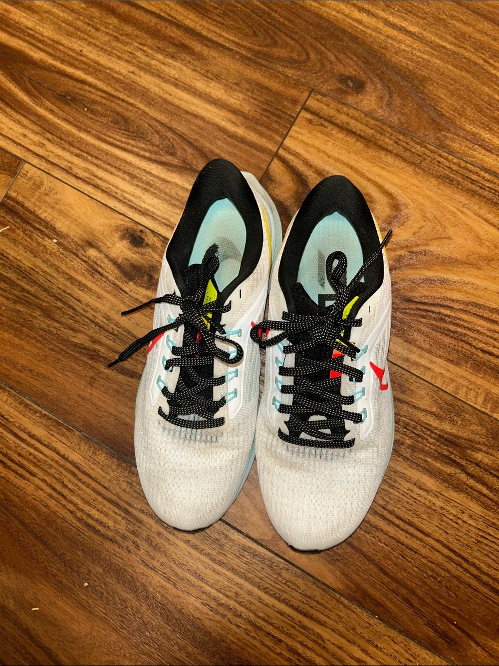 White Nike Running Sneakers with Black Accents and Red Logo